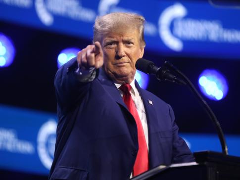 Donald Trump standing at a podium and pointing