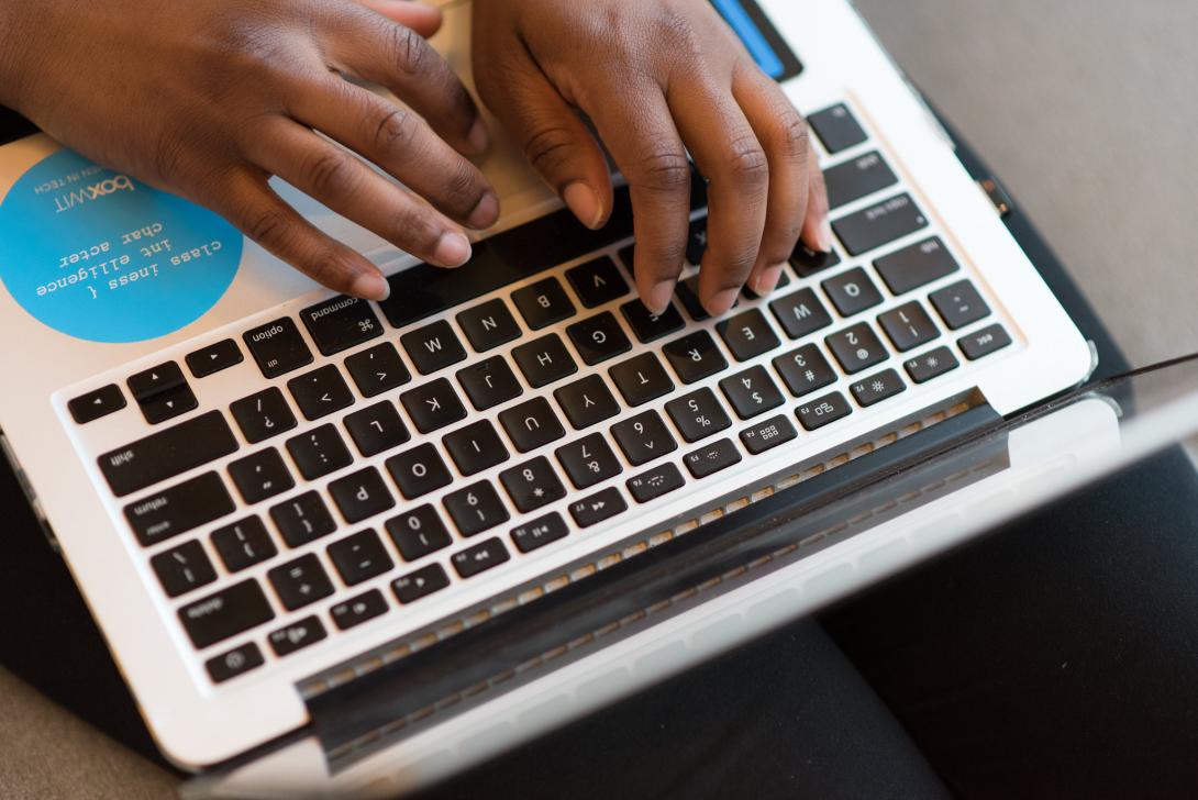 View of person's hands typing on a laptop