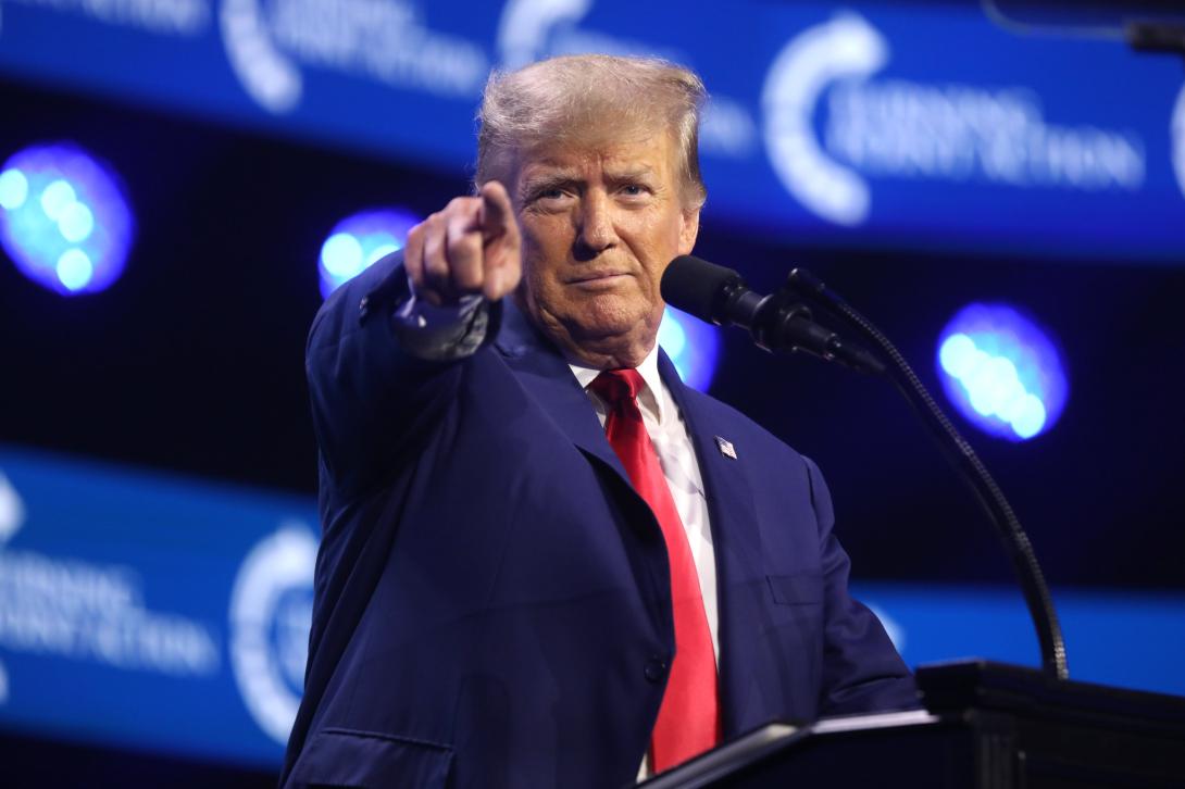 Donald Trump standing at a podium and pointing